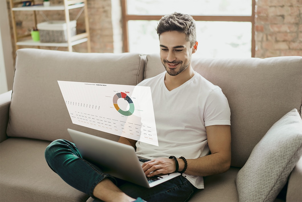 Mann analysiert Daten am Laptop auf Sofa