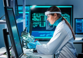 Frau analysiert Elektronik in Laborumgebung